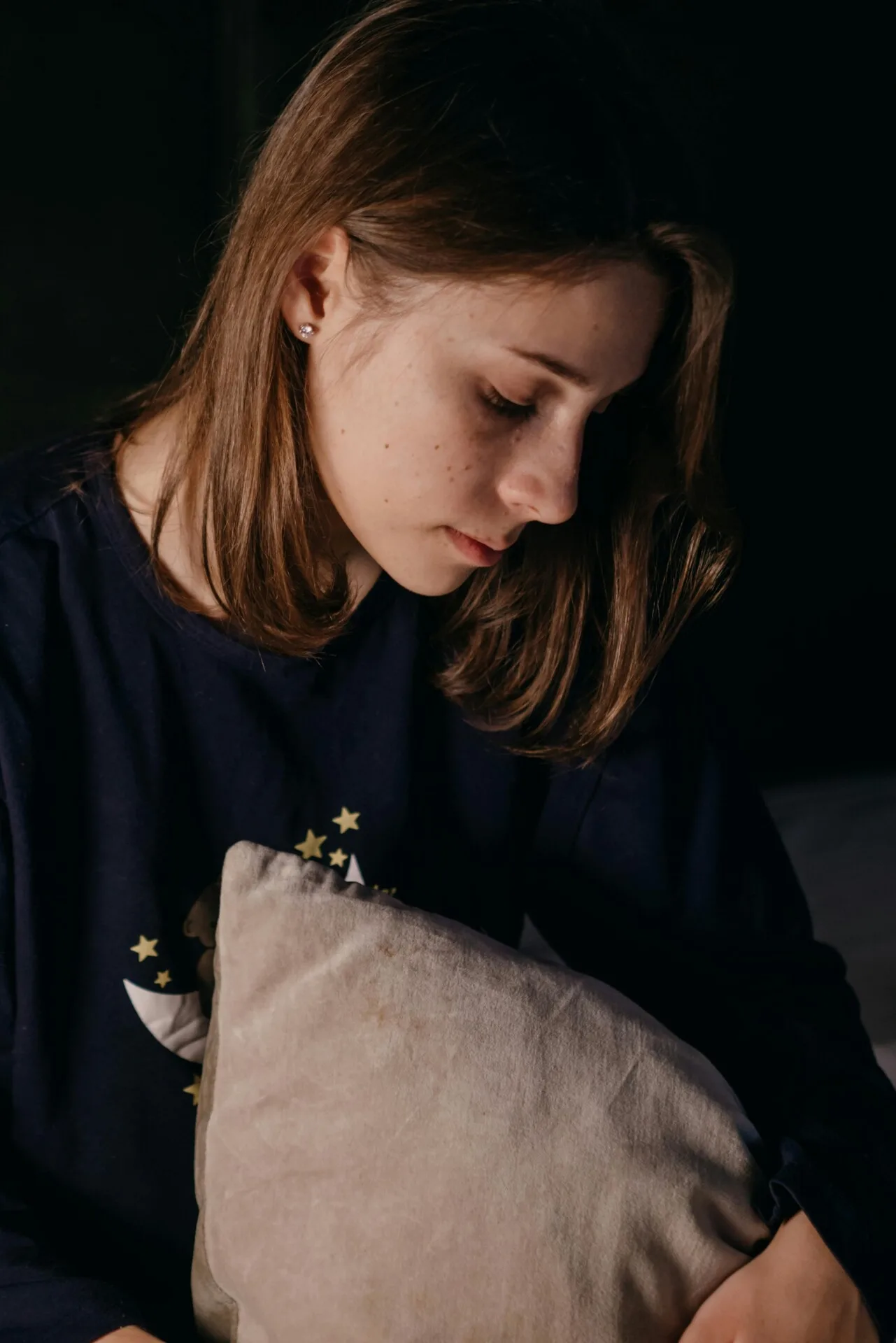 Kvinde med pude i favnen ser trist ud